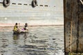 Dhaka, Bangladesh, February 24 2017: Two men ride their wooden boat on the river Royalty Free Stock Photo