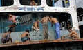 Dhaka, Bangladesh: A group of men washing on the back of a ship in the port at Sadarghat in Dhaka