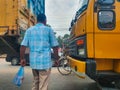 Dhaka,Bangladesh-July 13,2020:Man dangerously crossing road going through trucks during corona pandemic in South Asia