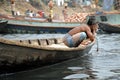 Dhaka, Bangladesh: A local man is bathing on a small boat on the river at Sadarghat in Dhaka