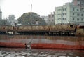 Dhaka, Bangladesh: Some men work on the deck of an old ship while another is fishing in the river