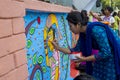 Art institute student painting a colorful wal