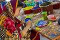 Art institute student painting a colorful mask.