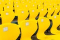 Empty yellow plastic chairs in symmetrical rows in a cricket stadium Royalty Free Stock Photo