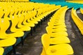 Empty yellow plastic chairs in symmetrical rows in a cricket stadium Royalty Free Stock Photo