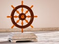 Dharma Wheel, Buddhist symbol. 3D illustration of the Buddhist symbol - Wheel of Dharma - made of wood on a marble base in a warm