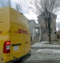 A DHL truck Back view parked in front of a house