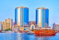 Dhow and abra boats on Dubai Creek against Rolex Towers of Deira, on March 1 in Dubai, UAE Royalty Free Stock Photo