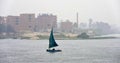 Peaceful view on the Nile: a sailing ship with blue sail