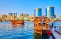 The dhow boat at the pier of Dubai Creek against Rolex Towers and Deira bank, UAE Royalty Free Stock Photo