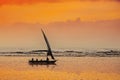 A Dhow fishing boat sailing in an orange sunset on the Indian Ocean near Mombasa, Kenya Royalty Free Stock Photo