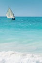 A dhow sailing off into the horizon on a blue sea Royalty Free Stock Photo