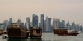 Dhows, the traditional boats, at the dhow harbour and, in the background, West Bay skyline. Doha. Qatar