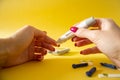 Diabet. Medical equipment. Medical concept. Close up of woman hands on yellow background using lancet on finger to check blood