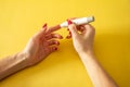 Diabet. Medical equipment. Medical concept. Close up of woman hands on yellow background using lancet on finger to check blood