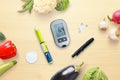 Diabetes concept composition with blood glucose meter and insulin surrounded by healthy food