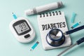 Diabetes concept with glucometer, lancet and stethoscope on blue background