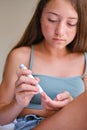 Diabetes and glycemia, a teenage girl examines her sugar level. Puncturing a child& x27;s finger with a lancet.