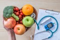 Diabetes monitor, Cholesterol diet and healthy food eating nutritional concept with clean fruits in nutritionist`s heart dish Royalty Free Stock Photo