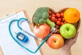 Diabetes monitor, Cholesterol diet and healthy food eating nutritional concept with clean fruits in nutritionist`s heart dish Royalty Free Stock Photo