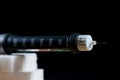 Diabetes pen close up macro shot on sugar cubes, focus on the needle isolated on black background. Royalty Free Stock Photo