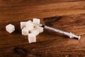 Diabetes is terrible disease. A lot of sugar cubes with syringe