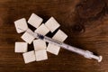 Diabetes is terrible disease. A lot of sugar cubes with syringe