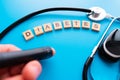 Diabetes wooden text. Flat lay composition with glucose meter and stethoscope on light blue background. Space for text