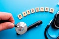 Diabetes wooden text. Flat lay composition with glucose meter and stethoscope on light blue background. Space for text