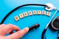 Diabetes wooden text. Flat lay composition with glucose meter and stethoscope on light blue background. Space for text