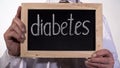Diabetes written on blackboard in therapist hands, high blood sugar problem