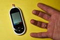 A diabetic checks his blood sugar. Close up man hands self-tested with a Lancet and a glucometer at home