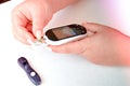 A diabetic checks his blood sugar. The woman is self-tested with a Lancet and a glucometer at home