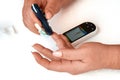 A diabetic checks his blood sugar. The woman is self-tested with a Lancet and a glucometer at home