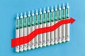 Diabetic insulin pens lined up in an ascending chart with a red uptrend arrow on a blue background