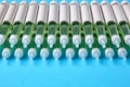 Diabetic insulin pens lined up on a blue background with copy space. Insurance coverage of medicines