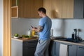 Diabetic man with CGM sensor checking his blood sugar level while making healthy breakfast. Royalty Free Stock Photo