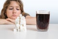 Diabetic woman is looking on glass with cola drink and heap of sugar. Unhealthy eating concept Royalty Free Stock Photo