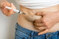 Diabetic woman with syringe inject insulin to her belly Royalty Free Stock Photo