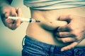 Diabetic woman with syringe inject insulin to her belly Royalty Free Stock Photo