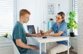 Diabetologist doctor testing blood sample on blood sugar meter in diabetes clinic. Doctor taking blood sample from