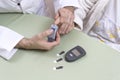 Diabetologist punctures the finger of a woman suffering from diabetes. Royalty Free Stock Photo