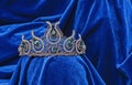 Diadem with green stones on a blue velvet background. Eastern tiara. Jewelry design