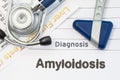 Diagnosis Amyloidosis. Neurological hammer, stethoscope and liver laboratory test lie on note with title of Amyloidosis. Concept f