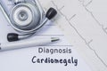 Diagnosis of cardiomegaly. Stethoscope, printed electrocardiogram and pen are on paper medical form where indicated cardiological