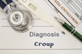 Diagnosis Croup. Stethoscope, electronic thermometer, patient blood test results lying on medical history, which is written diagno