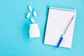 Diagnosis of the disease. Notebook with pen and pills on a blue background Royalty Free Stock Photo