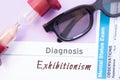 Diagnosis of Exhibitionism. Hourglass, doctor glasses, mental status exam are near inscription Exhibitionism. Causes, symptoms, di