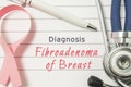 Diagnosis Fibroadenoma of Breast. Pink ribbon as symbol of struggle with breast diseases and stethoscope lying on medical form wit