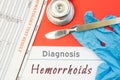 Diagnosis Hemorrhoids. Blue gloves, surgical scalpel, syringe and ampoule with medicine lie next to inscription Hemorrhoids. Cause Royalty Free Stock Photo